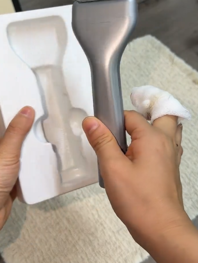 Handheld shaver beside its packaging